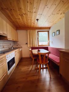 a small kitchen with a table and a couch at Appartements Birkenhof in Lech am Arlberg