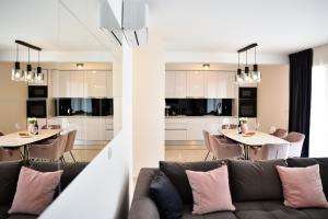 een woonkamer en een keuken met een bank en tafels bij Luxury Apartments La Perla in Bibinje