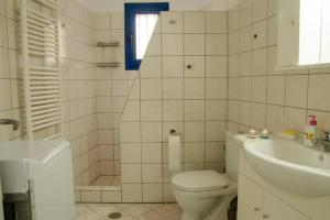 a white bathroom with a toilet and a sink at Cycladic houses in rural surrounding 3 in Tholária +7 photos