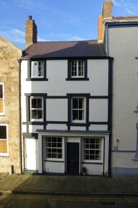 uma casa branca e preta com garagem em Totters townhouse em Caernarfon