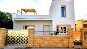 a white house with a fence in front of it at B&B Filieri in Santa Maria al Bagno