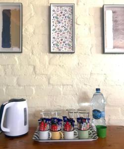 einen Tisch mit Tassen und eine Flasche Wasser in der Unterkunft Old Transvaal Inn Accommodation in Dullstroom