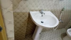 een witte wastafel in een badkamer met een toilet bij Umaya Holiday Home in Anuradhapura