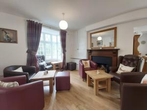 a living room with purple furniture and a piano at Penbont House in Rhayader