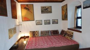 1 dormitorio con 1 cama y cuadros en la pared en The old olive mill house en Aegae