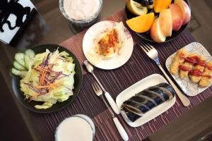 una mesa con platos de comida y cuencos de fruta en Min Le Yuan B&B, en Hualien City