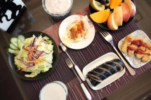 花蓮市的住宿－民樂緣民宿 ，餐桌,盘子上放着食物和水果碗