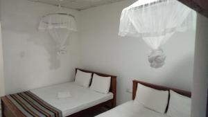 een kleine kamer met 2 bedden en een raam bij Umaya Holiday Home in Anuradhapura
