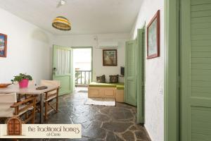 Habitación con puertas con persianas verdes, mesa y sillas. en Elounda Collection Apartments, en Elounda