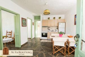 cocina y comedor con mesa y sillas en Elounda Collection Apartments, en Elounda