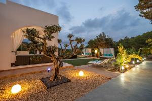 a house with a tree in the middle of a yard at Can Garchet White Ibiza in Sant Jordi