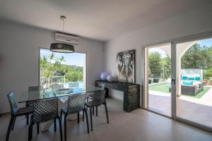 a dining room with a glass table and chairs at Can Garchet White Ibiza in Sant Jordi