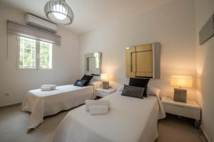 a room with two beds and two lamps in it at Can Garchet White Ibiza in Sant Jordi +46 photos