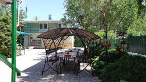 a table and chairs under an umbrella in a garden at Зюйд in Gribovka