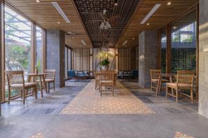 een eetkamer met tafels en stoelen en ramen bij Le Boutique Danang in Da Nang