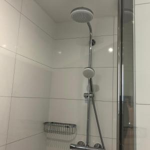 a shower with two shower heads in a bathroom at Zoutelande Koddelaan vakantiewoning in Zoutelande
