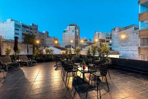 a rooftop patio with tables and chairs at night at Nin&Bau Sarri 2 in Athens