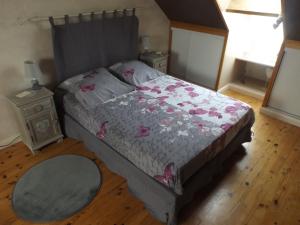 una camera da letto con un letto e un copriletto con fiori rosa di Les Eléphants bleus a Onzain