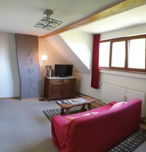 a living room with a pink couch and a tv at Be.Cosy in Brussels