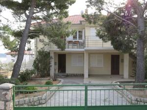 a house with a fence in front of it at Rab From Above Studio Apartment in Rab