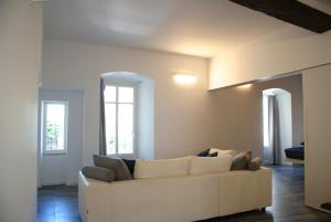 ein weißes Sofa im Wohnzimmer mit zwei Fenstern in der Unterkunft Albergo Diffuso Vulcano Village in Castro