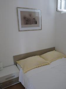 a bedroom with a bed and a picture on the wall at Rab From Above Studio Apartment in Rab