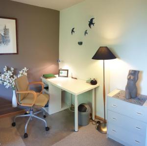 ein Büro mit einem Schreibtisch, einer Lampe und einem Stuhl in der Unterkunft Be.Cosy in Brüssel