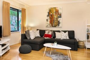 uma sala de estar com um sofá e uma mesa em Perth Short Stays em Perth