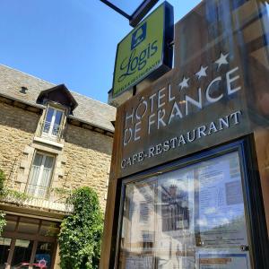 um sinal para uma loja em frente a um edifício em Logis Hôtel Restaurant de France em Saint-Geniez-dʼOlt