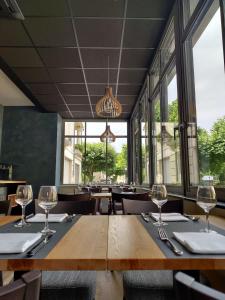 サン・ジュニエ・ドルトにあるLogis Hôtel Restaurant de Franceのダイニングルーム(ワイングラス付きのテーブル付)
