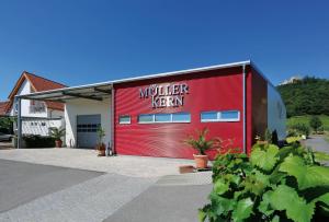 a red building with a murder farm sign on it at Weingut & Ferienwohnungen Müller-Kern in Neustadt an der Weinstraße