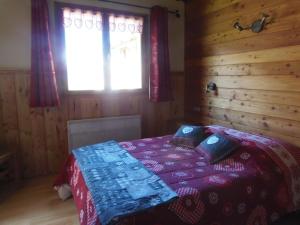 ein Schlafzimmer mit einem Bett in einem Holzzimmer in der Unterkunft Chalet l'aubépine résidence B&B in Bessans