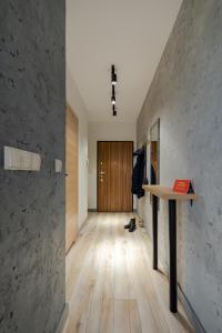 een hal met een tafel en een houten deur bij Grey Horse Apartments in Gdańsk