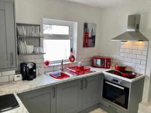 eine Küche mit einer roten Spüle und einer Mikrowelle in der Unterkunft Plymouth Hoe Hideaway in Plymouth + 9 Fotos