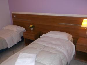 a hotel room with two beds and two night stands at Albergo Meublè Abatjour in Mantova