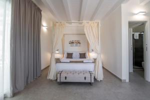 a bedroom with a white bed with a canopy at Pietra Bianca Marzamemi in Marzamemi