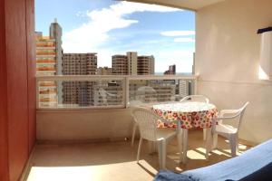 een tafel en stoelen op een balkon met uitzicht op de stad bij Apartamento vacaciones en Gemelos 22 in Benidorm
