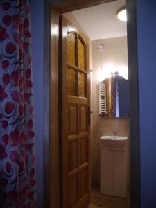 a bathroom with a wooden door and a sink at Pod kasztanem gospodarstwo agroturystyczne in Stronie Śląskie