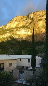 a building with a mountain in the background at The old olive mill house in Aegae