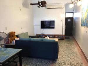 a living room with a blue couch and a teddy bear at 瑞恒行館Reui Heng Guesthouse in Budai