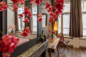 a room with a bed and a table and a mirror at Guesthouse Maison de la Rose in Bruges