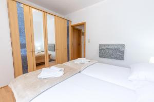 a bedroom with two beds with white sheets at Apartman Lana in Baška