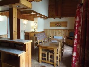 ein Esszimmer mit einem Holztisch und Stühlen in der Unterkunft Chalet l'aubépine résidence B&B in Bessans