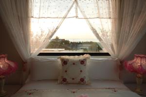 a bed in front of a window with a pillow at Min Le Yuan B&B-include long stay in Hualien City