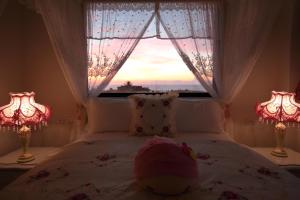 a bedroom with a bed with two lamps and a window at Min Le Yuan B&B-include long stay in Hualien City