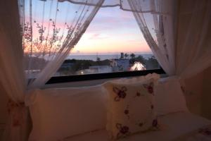 a bedroom with a window with a view of the sunset at Min Le Yuan B&B-include long stay in Hualien City