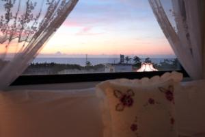 a window with a view of a sunset at Min Le Yuan B&B-include long stay in Hualien City