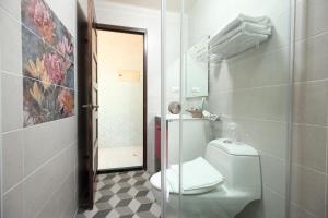 a bathroom with a white toilet and a mirror at Min Le Yuan B&B-include long stay in Hualien City