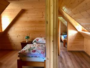 a bedroom with a bed in a wooden cabin at Serce Beskidu Niskiego in Świątkowa Mała