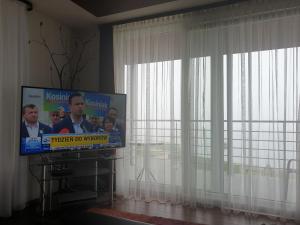 a flat screen tv in a room with a window at Riwiera in Mielno